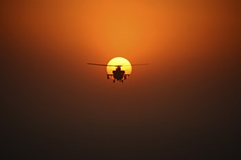 An AH-64D Apache Helicopter Flying into the Sun over Iraq by Terry Moore/Stocktrek Images art print