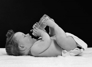 1950s Baby Lying On Back Drinking From Bottle by Vintage PI art print